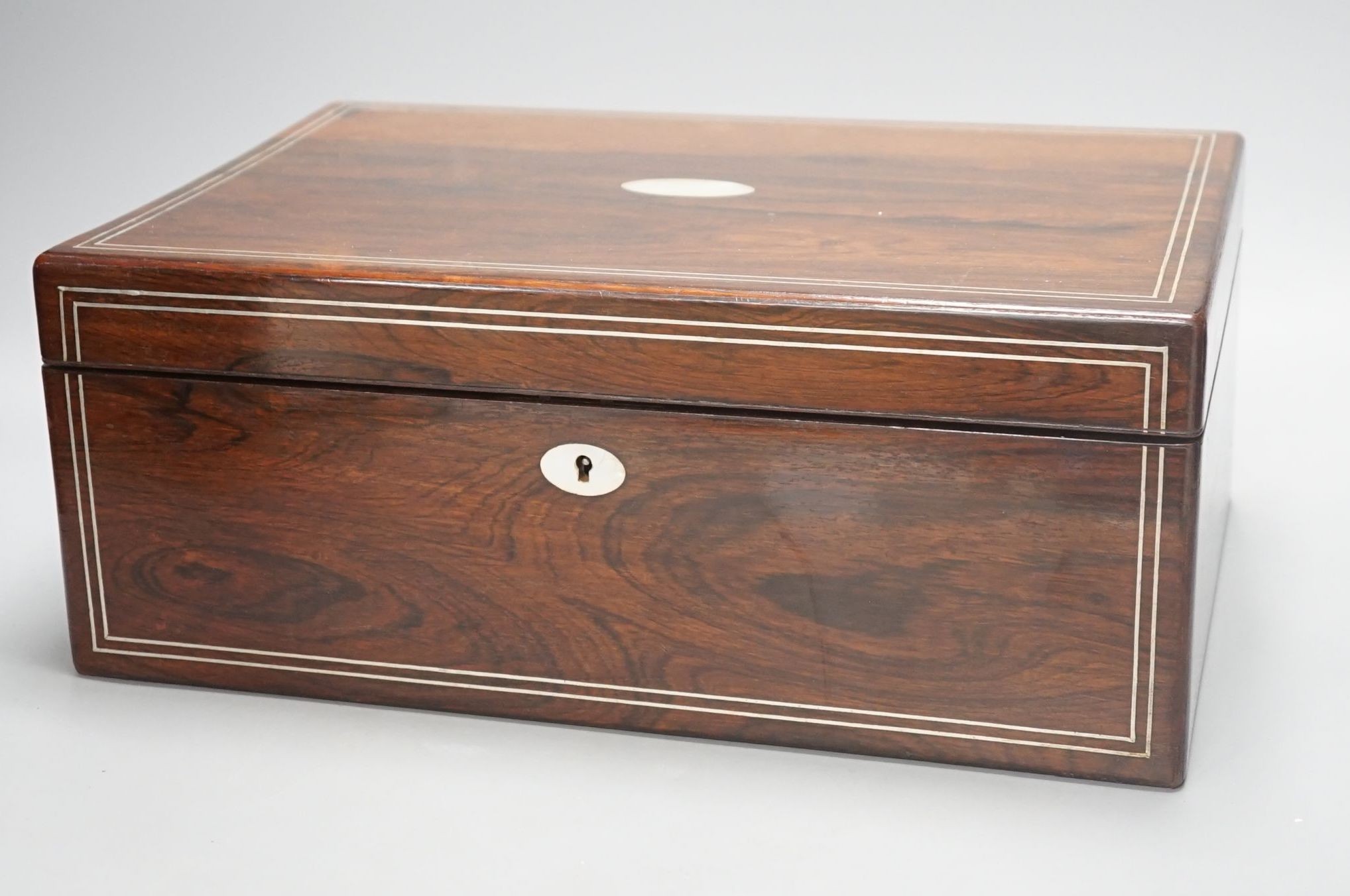 A Victorian rosewood sewing box containing white metal lidded glass bottles, box 37 cms wide x 15 cms high.